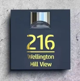 Square solar-powered custom acrylic house sign with engraved gold address number and text on dark background