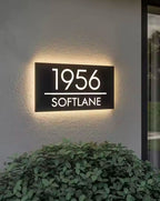 Custom rectangular LED light-up house address sign displaying 1956 Softlane on exterior wall at night