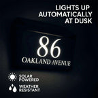 Solar-powered modern acrylic house sign glowing at dusk with custom address 86 Oakland Avenue, weather-resistant design.