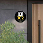 Round black solar-powered acrylic house sign with yellow address number 302 and Chestnut Street text mounted outdoors
