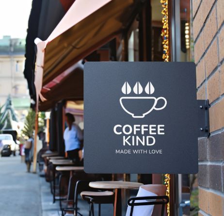 Modern square business signage lightbox mounted on brick wall displaying coffee shop logo and text