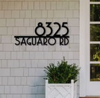 House number sign '8325 Saguaro Rd' on a tiled wall.