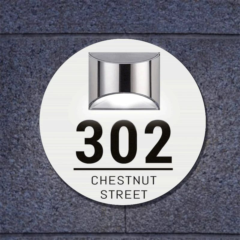 Circular solar-powered acrylic house sign with address number 302 and Chestnut Street engraving on stone wall