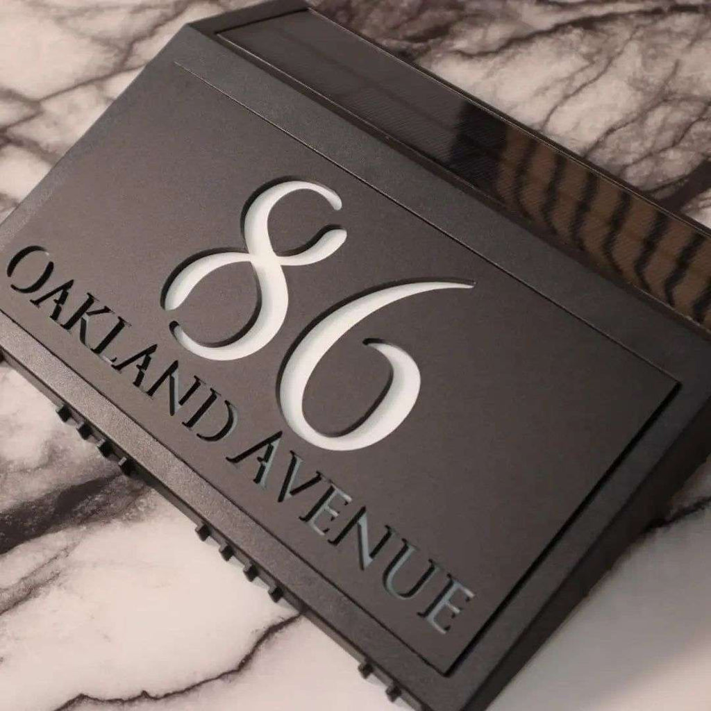 Modern solar-powered custom acrylic house sign with laser-etched address numbers and text on black panel