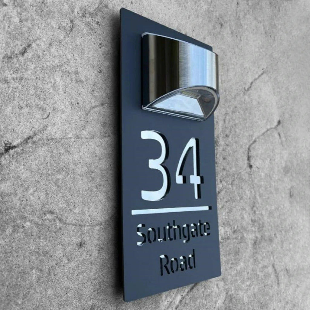Rectangular custom acrylic house number sign with mirrored cutout lettering and a modern light fixture above.