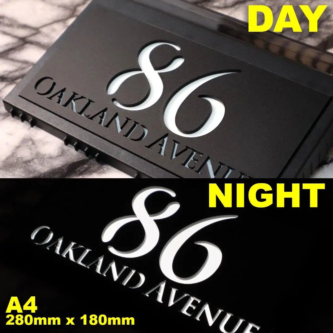Custom solar acrylic house sign displaying 86 Oakland Avenue with illuminated numbers at night.