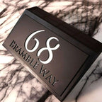 Modern solar-powered custom acrylic house sign with address number and street name on black background